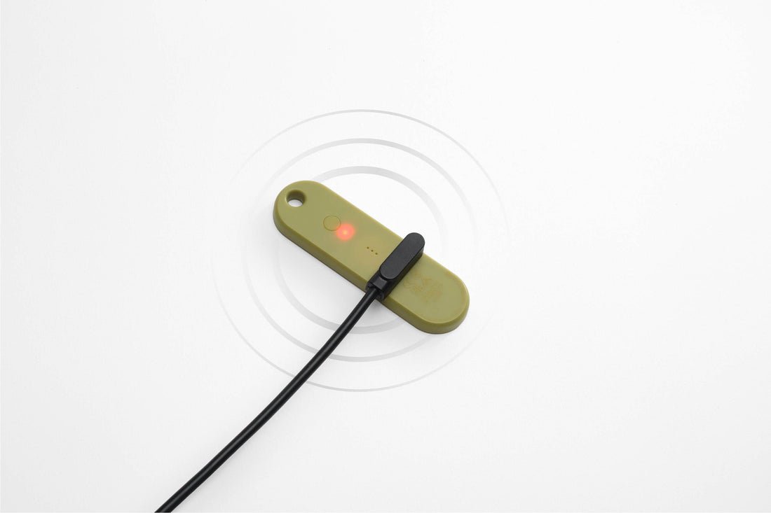 Orbitkey Universal Tracker on its magnetic charging cable